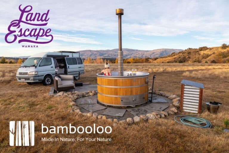 A LandEscape Wanaka promotional image: a campervan beside a wood-fired hot tub in open tussock country, carrying the LandEscape and Bambooloo logos